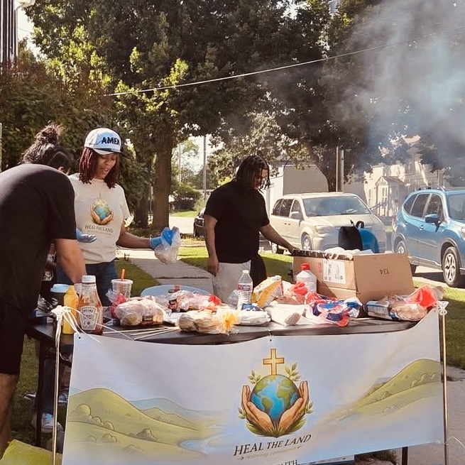 Volunteers serving a free meal under the Heal the Land banner