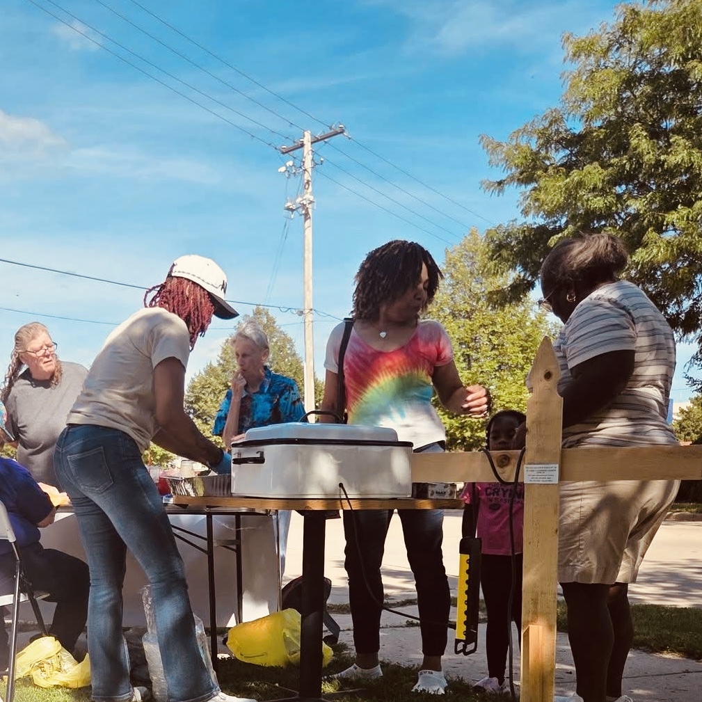 Neighbors gathered around the serving table on a sunny afternoon